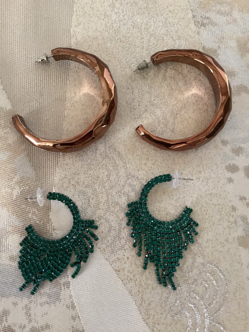 Two inch copper hoop earrings and two inch green rhinestone earrings